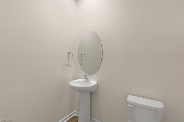 bathroom with toilet and baseboards