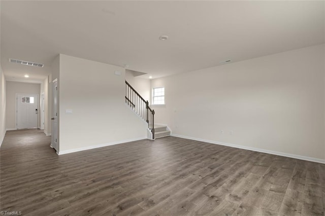 unfurnished living room featuring recessed lighting, visible vents, baseboards, stairway, and dark wood-style floors