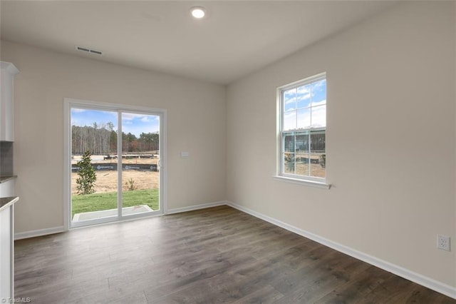 unfurnished room with dark wood-style floors, recessed lighting, visible vents, and baseboards