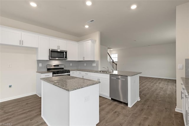 kitchen with a peninsula, visible vents, appliances with stainless steel finishes, and white cabinets