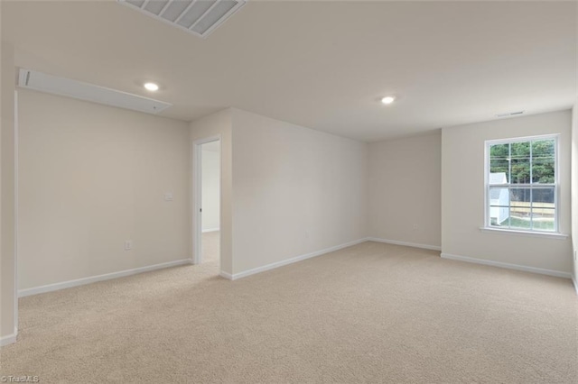 unfurnished room with light carpet, recessed lighting, visible vents, and baseboards