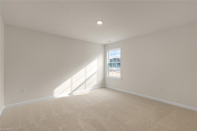 carpeted empty room featuring baseboards