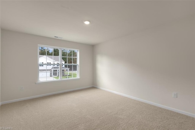 unfurnished room featuring light carpet, visible vents, and baseboards