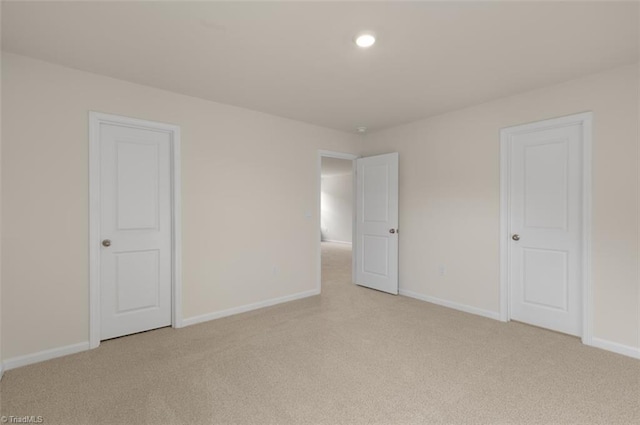 interior space featuring light carpet, recessed lighting, and baseboards