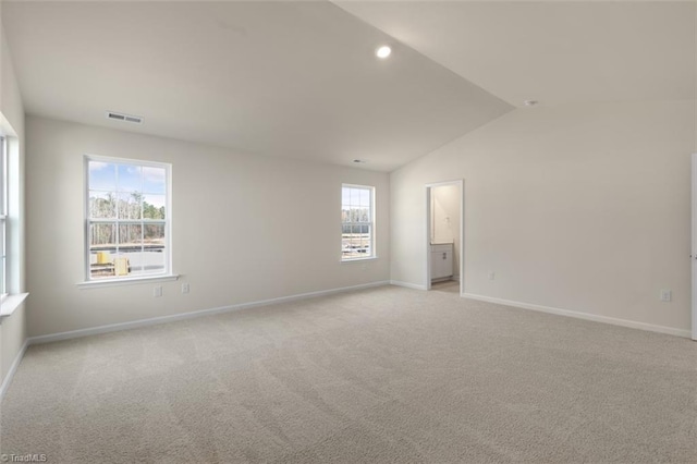 spare room with recessed lighting, light colored carpet, visible vents, baseboards, and vaulted ceiling