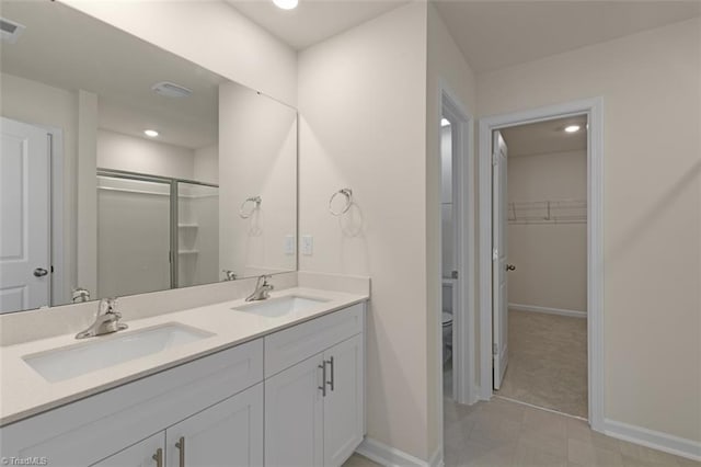 full bathroom featuring a stall shower, a sink, toilet, and double vanity