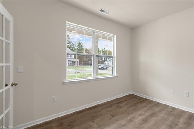 empty room with visible vents, baseboards, and wood finished floors