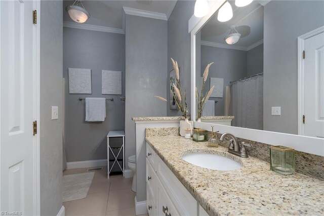 bathroom with ornamental molding, vanity, tile patterned flooring, and toilet