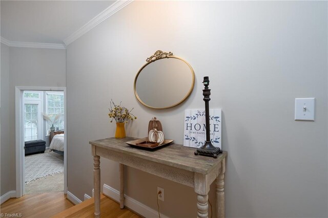 hallway featuring ornamental molding and light hardwood / wood-style flooring