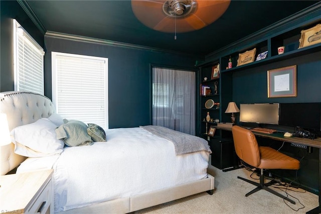 carpeted bedroom featuring ceiling fan and crown molding