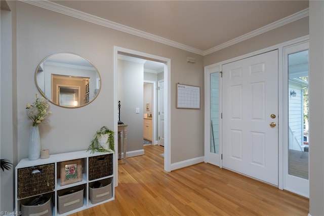 foyer with ornamental molding and light hardwood / wood-style floors