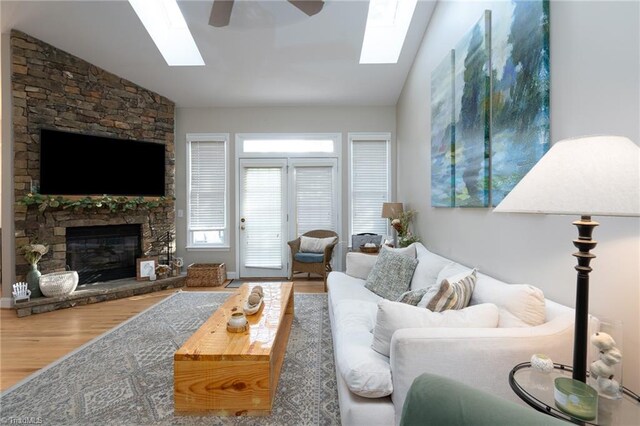 living room featuring ceiling fan, lofted ceiling, a fireplace, and hardwood / wood-style floors