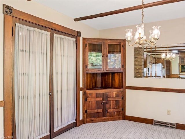 interior space featuring carpet, white fridge, and an inviting chandelier