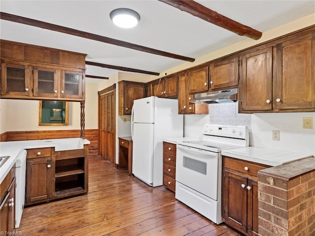 kitchen with white appliances, beamed ceiling, and dark hardwood / wood-style floors