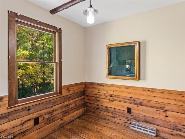 unfurnished room featuring wood walls