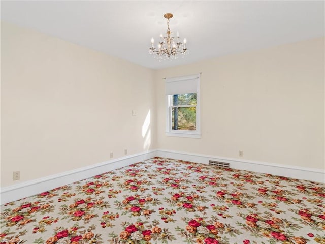 spare room with a notable chandelier