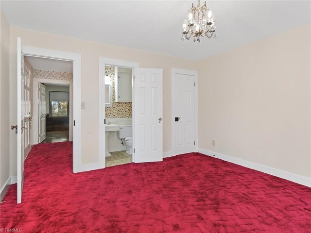 unfurnished bedroom featuring carpet floors, ensuite bath, and a chandelier