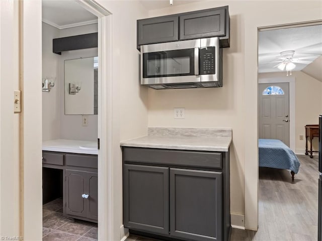 interior space with vanity, crown molding, hardwood / wood-style flooring, and ceiling fan