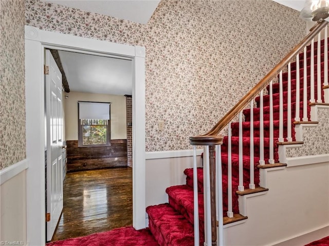 stairs with hardwood / wood-style floors and wood walls