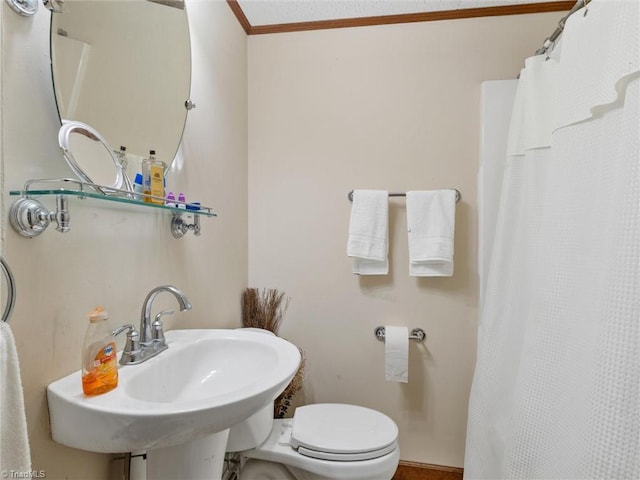 bathroom featuring crown molding, walk in shower, sink, and toilet