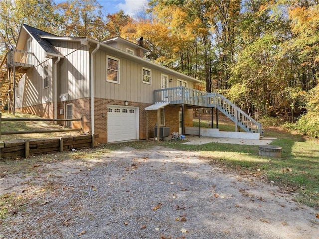 back of property featuring cooling unit, a deck, and a garage