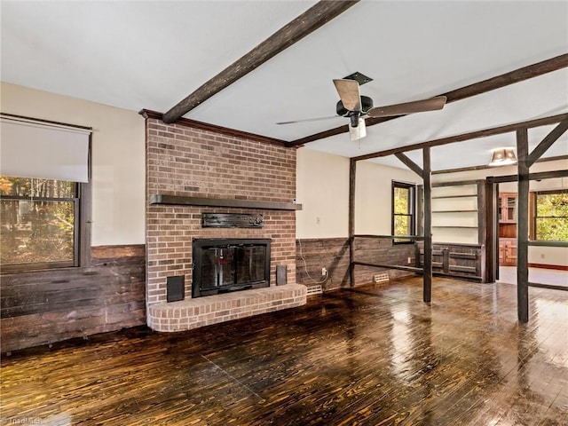 unfurnished living room featuring beam ceiling, a fireplace, hardwood / wood-style flooring, and ceiling fan