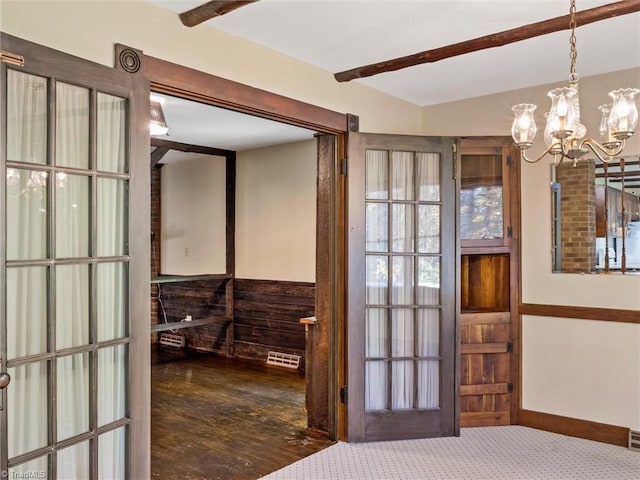 entryway with dark carpet and an inviting chandelier