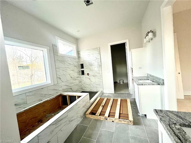 bathroom with a tub to relax in and tile patterned floors