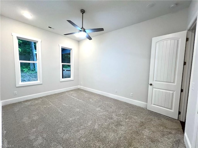 empty room with ceiling fan and carpet flooring