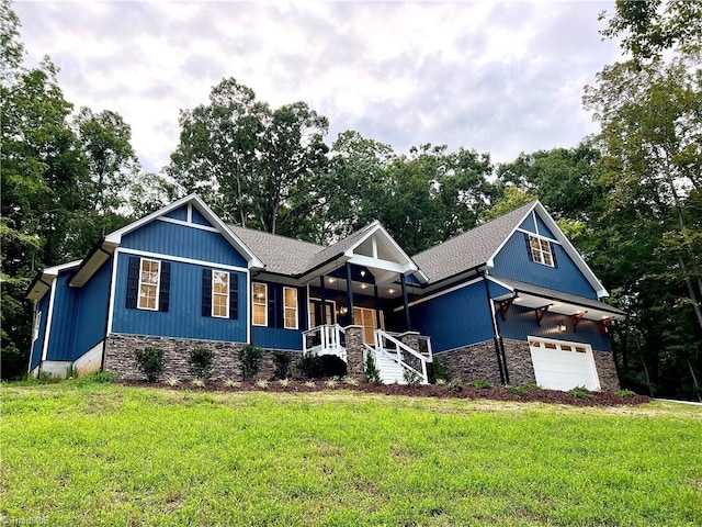 craftsman inspired home featuring a garage, covered porch, and a front yard