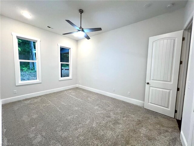 carpeted spare room with ceiling fan