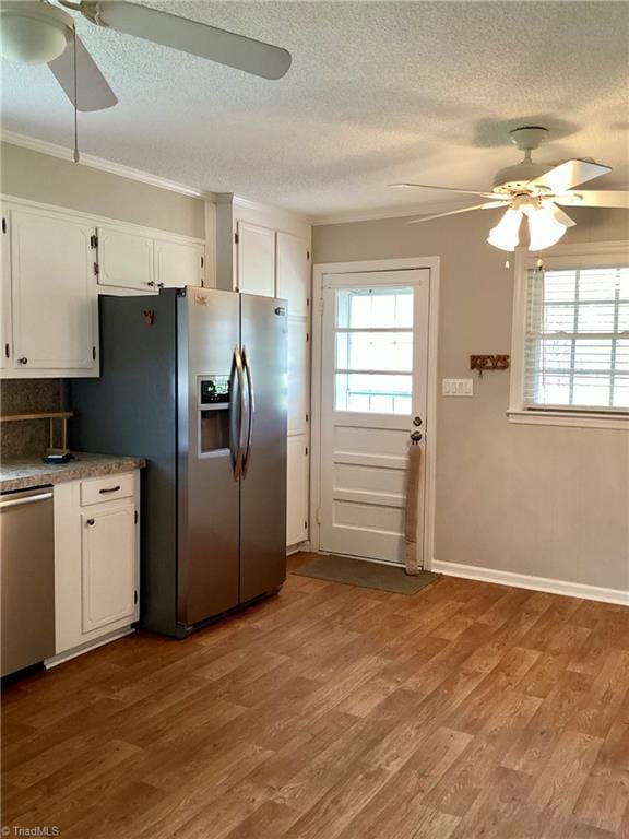 kitchen featuring plenty of natural light, wood finished floors, and stainless steel appliances