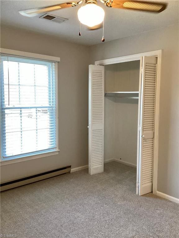 unfurnished bedroom featuring carpet, baseboards, visible vents, a baseboard radiator, and a closet