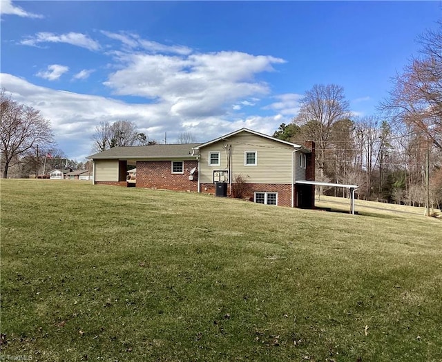 back of property with brick siding and a yard