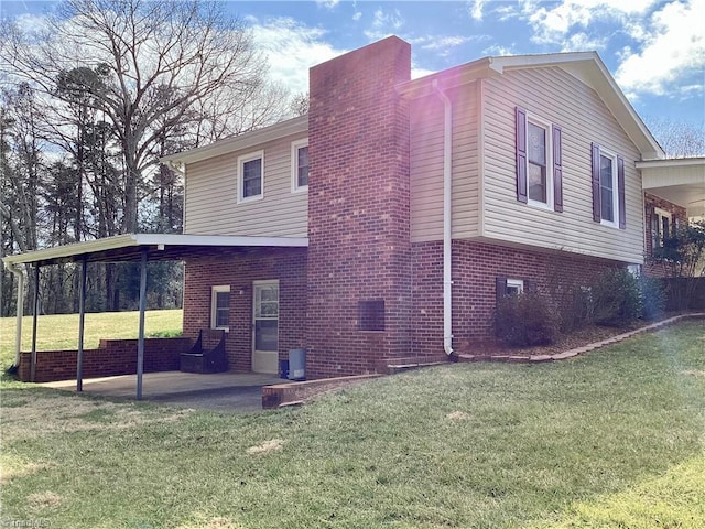 view of home's exterior with a patio area, brick siding, and a yard