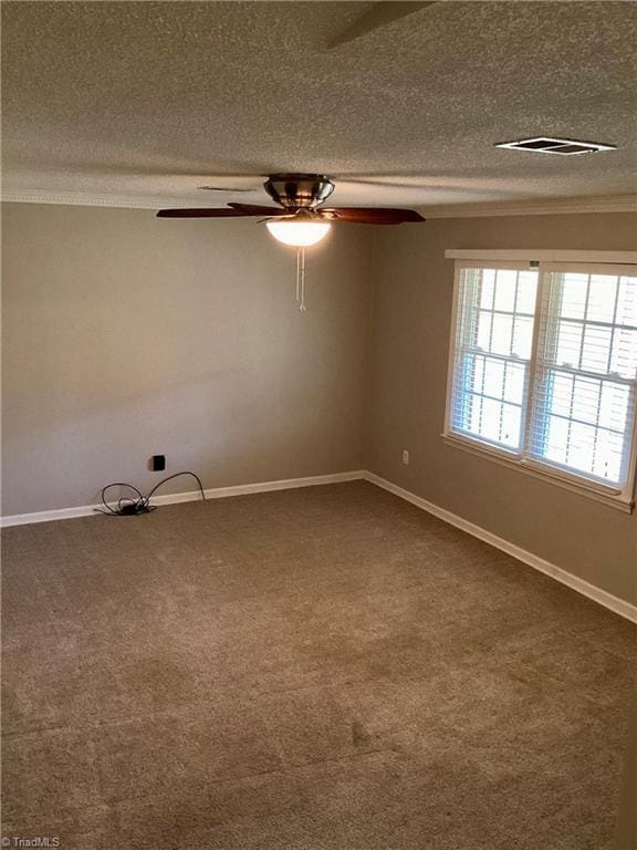 unfurnished room featuring baseboards, visible vents, a textured ceiling, crown molding, and dark carpet