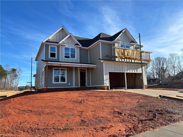 view of front of house with concrete driveway, a balcony, a garage, and board and batten siding