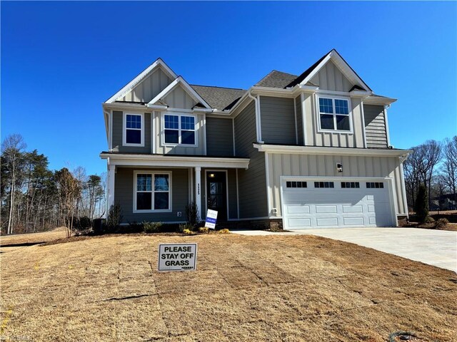 view of front facade with driveway, covered porch, board and batten siding, and an attached garage