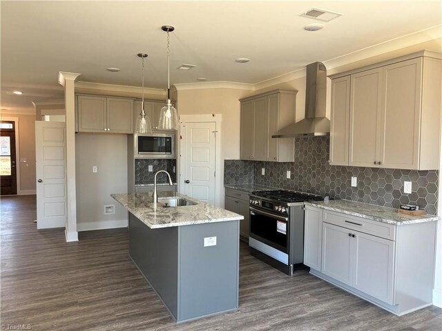 kitchen with visible vents, a sink, stainless steel appliances, wall chimney exhaust hood, and crown molding