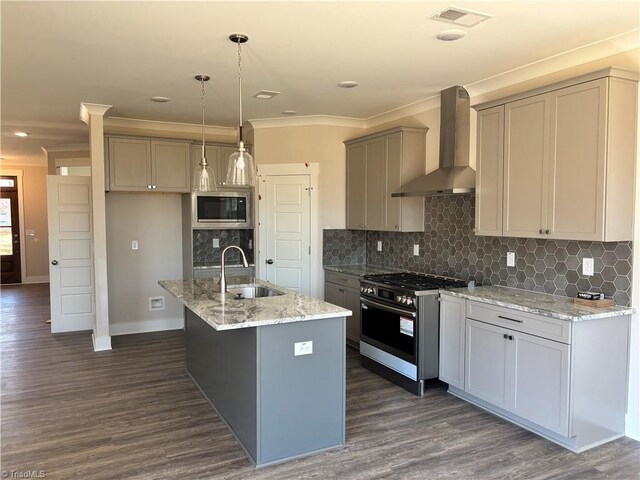 kitchen with visible vents, crown molding, stainless steel appliances, wall chimney exhaust hood, and a sink