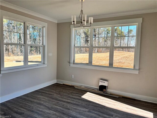 unfurnished dining area featuring a chandelier, baseboards, ornamental molding, and dark wood finished floors