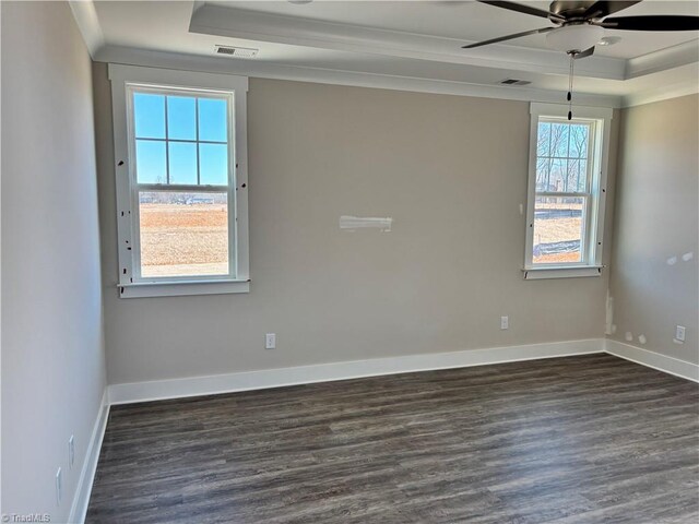 unfurnished room featuring a ceiling fan, dark wood-style floors, visible vents, crown molding, and a raised ceiling