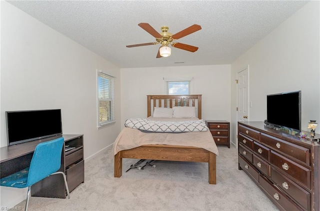 bedroom with visible vents, light carpet, ceiling fan, and a textured ceiling