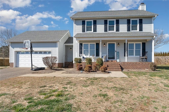 view of front of home featuring driveway, a garage, a chimney, covered porch, and a front lawn