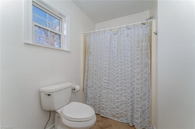 bathroom featuring a textured ceiling and toilet