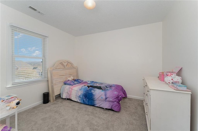 bedroom featuring baseboards, a textured ceiling, visible vents, and light colored carpet