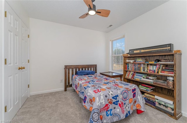 bedroom featuring light colored carpet, ceiling fan, visible vents, and baseboards