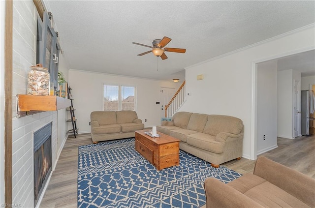 living room featuring a textured ceiling, stairway, and light wood-type flooring