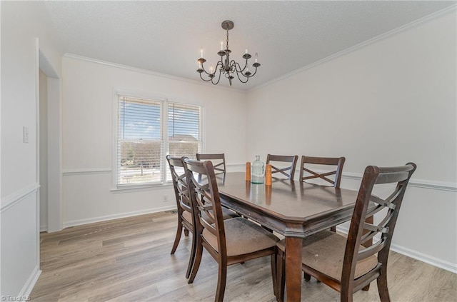 dining space with crown molding, baseboards, light wood-style flooring, and a notable chandelier