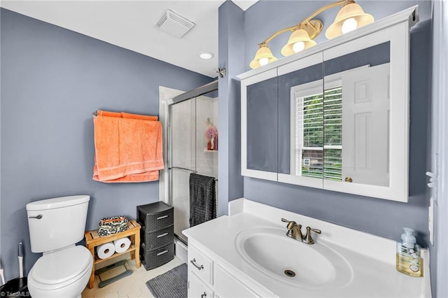 bathroom with toilet, vanity, tile patterned floors, and a shower with shower door